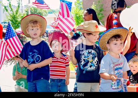 Children wave American flags during a Fourth of July parade, June 30, 2011, in Columbus, Mississippi. Stock Photo