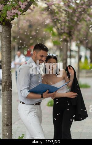 Two business people laughinf under the falling flower leafs, selective focus Stock Photo