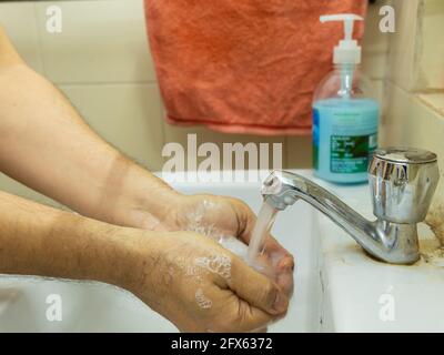 Hands being washed with soap under tap in a sink with empty copy space Stock Photo