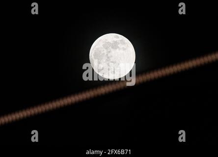 Malla, Spain. 26th May, 2021. The second super full moon of the year, known as 'flower moon', is seen rising over the sky. The super moon is an astronomical event that produces a visual effect in the moon with an appearance bigger and shiny than normal. (Photo by Jesus Merida/SOPA Images/Sipa USA) Credit: Sipa USA/Alamy Live News Stock Photo