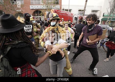 A Los Angeles Fire Department firefighter sprays water on a burning ...