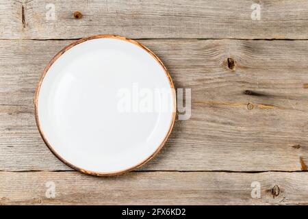 Empty white ceramic dish on rustic wooden table Stock Photo