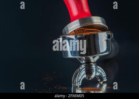 https://l450v.alamy.com/450v/2fx6m05/barista-accessories-portafilter-with-fresh-ground-coffee-and-tamper-on-shiny-table-bar-2fx6m05.jpg