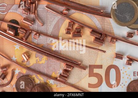 Fifty euro banknote, coins and scrap of copper wire top view, trading and investing in raw metal materials concept Stock Photo