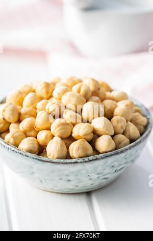 Peeled roasted hazelnut kernels in bowl. Stock Photo
