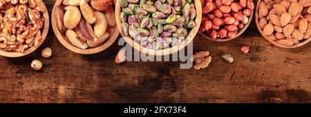 Nuts panorama, top shot with copy space on a dark rustic wooden background Stock Photo