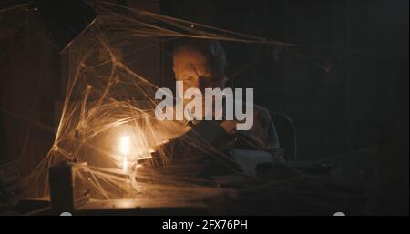 Corporate businessman searching for paperwork in an abandoned office: failure, financial crisis and outdated business concept Stock Photo