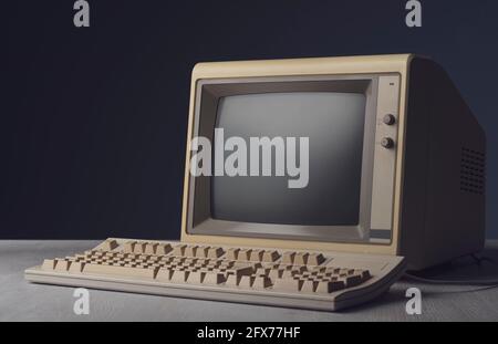 Vintage personal computer with keyboard on a desktop, outdated electronics concept Stock Photo