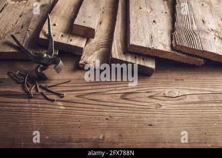 Rustic wooden boards pincers and rusty nails on the carpenter table Stock Photo