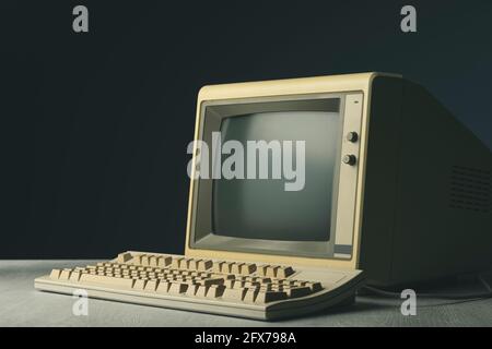 Vintage personal computer with keyboard on a desktop, outdated electronics concept Stock Photo