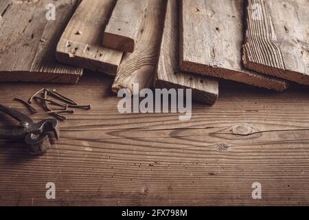 Rustic wooden boards pincers and rusty nails on the carpenter table Stock Photo