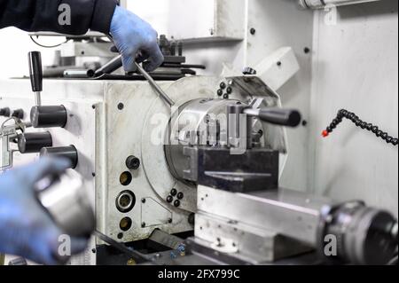Close up view of worker operating a high precision turning operation on a multi axis lathe, CNC machine tool. High quality photo. Stock Photo