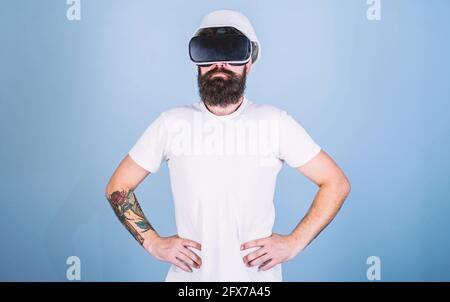 Man with beard in VR glasses serious and confident, light blue background. Architect or engineer with virtual reality glasses. Guy in helmet works as Stock Photo