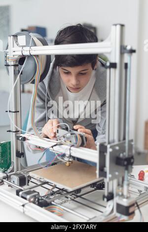 Young smart student using a 3D printer in the lab, engineering and technology concept Stock Photo