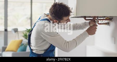 Professional plumber checking a boiler and pipes, boiler service concept Stock Photo