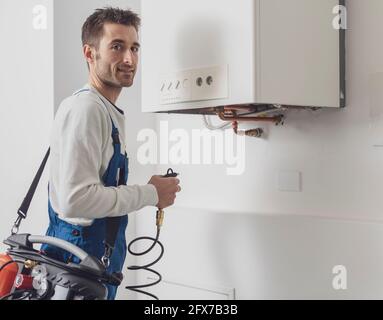 Plumber checking a boiler using professional tools, boiler servicing concept Stock Photo
