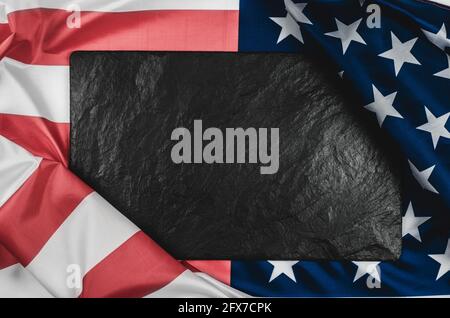 Black stone plaque on the American flag with place for text. Stock Photo
