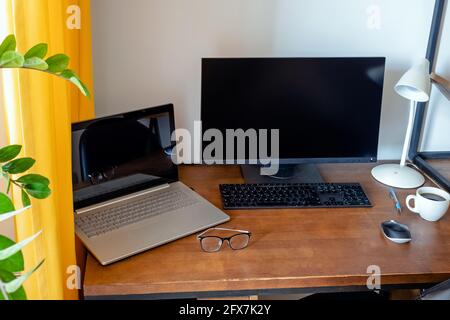 Workplace with wooden table and green plant. Stock Photo