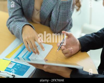 Top view of businesspeople discussing on their work with digital tablet on meeting table Stock Photo