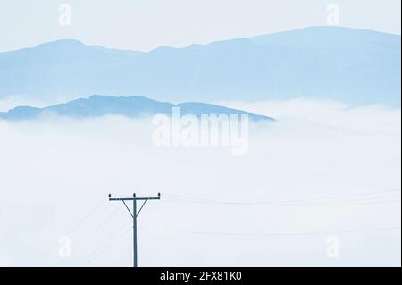 Telegraph poles above clouds, Norway Stock Photo