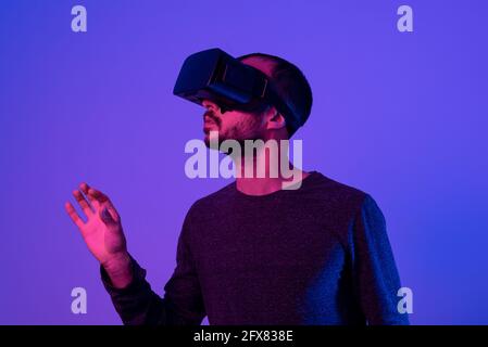 young man working with vr headset device, moving virtual object with his hands. using new technology at work Stock Photo