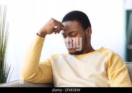 Upset black guy suffering from headache, closeup Stock Photo