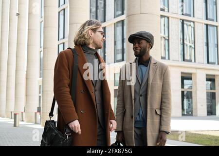 Two young men in stylish coats standing in the city Stock Photo