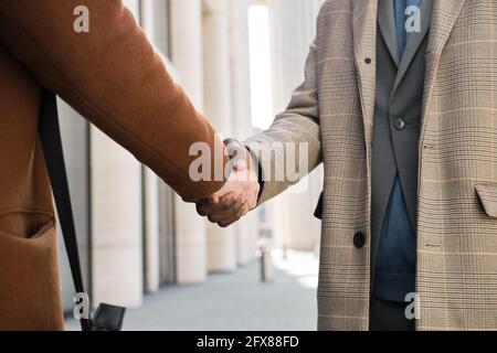 Close-up of business people shaking hands at meeting at the city Stock Photo