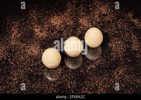 Chocolate candies on a dark background with reflection. Piece by piece and as a whole. Filling of nuts and fruits. Copy space. Stock Photo