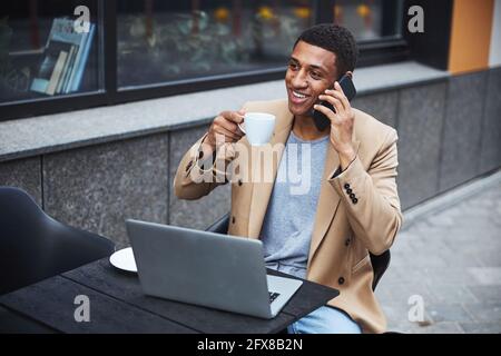 Handsome male having pleasant conversation per telephone Stock Photo