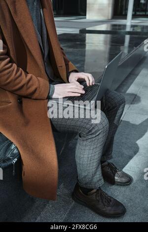 Close-up of young businessman working on computer outdoors Stock Photo