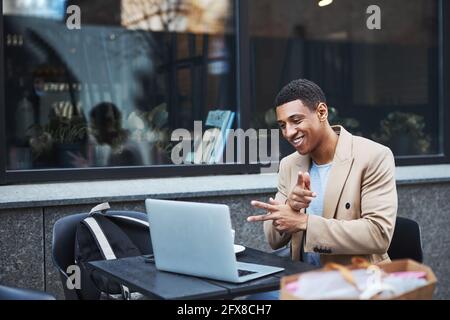 Joyful male person having pleasant video conversation Stock Photo