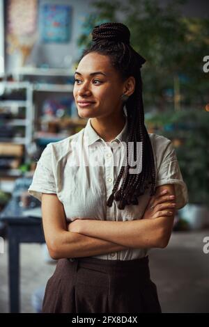 Dark-haired floral decorator daydreaming in her workplace Stock Photo