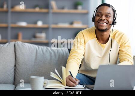 Joyful black guy having online class at home Stock Photo