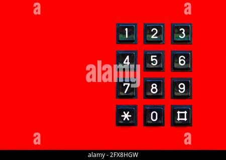 Simple red old classic retro landline phone keypad background, copy space. Vintage wired telephone number pad dial keyboard closeup, top view, from ab Stock Photo