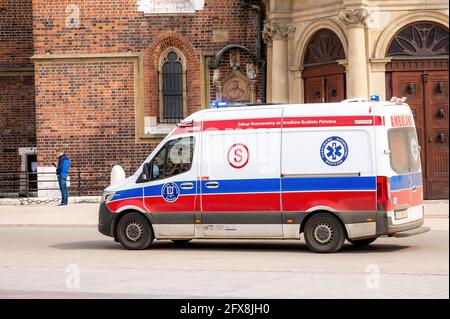 Krakow, Poland, Polish ambulance with sirens on moving, driving through the Cracow Main Market Square, emergency vehicle closeup, medical transportati Stock Photo