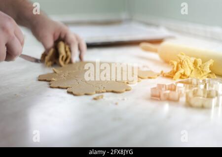 Woman collecting the leftovers of daugh after cutting it in the heart shape Stock Photo