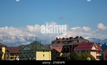 Roofs of houses against the background of mountains and the sky. small town in a mountainous area Stock Photo