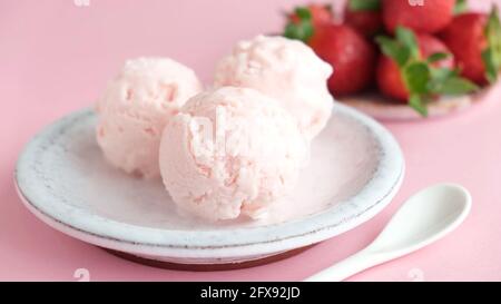 Strawberry ice cream scoops on a plate. Homemade pink strawberry ice cream, italian gelato Stock Photo