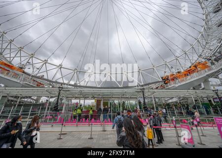 London, UK. 26 May 2021. Grey cloud and cool temperatures in central London with an improvement forecast later in the week. A queue of visitors for the London Eye, in spite of the weather. Credit: Malcolm Park/Alamy Live News. Stock Photo