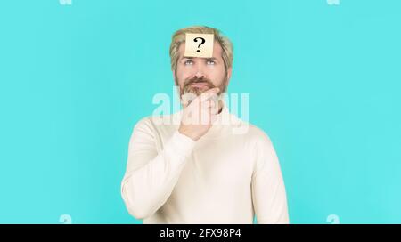 Man with question mark on forehead looking up. Paper notes with question marks. Beard man question mark in head, solution problems. Thinking man with Stock Photo