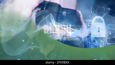 Composition of blue light trails and online security padlock over man wearing vr headset Stock Photo