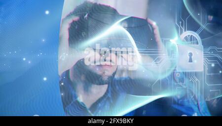 Composition of blue light trails and online security padlock over man wearing vr headset Stock Photo