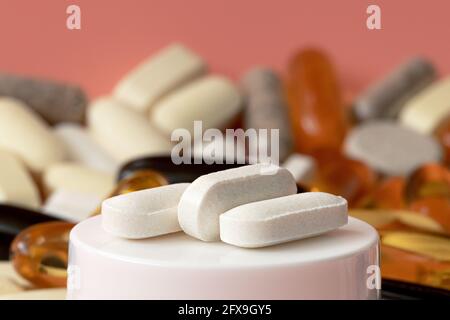 close-up of magnesium amino acid complex tablets on the background of multivitamin pills. mental wellbeing and personal health concept Stock Photo