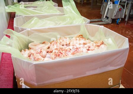 Chicken feet, chicken feet that are cut into many pieces in a large box.Line for the production of meat with packaging and cutting . Industrial equipm Stock Photo