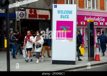 London, UK.  26 May 2021.  People pass a Welcome Back sign on Oxford Street as retailers hope that the easing of lockdown results in increased store sales as evidence of pent-up demand from shoppers.  Credit: Stephen Chung / Alamy Live News Stock Photo