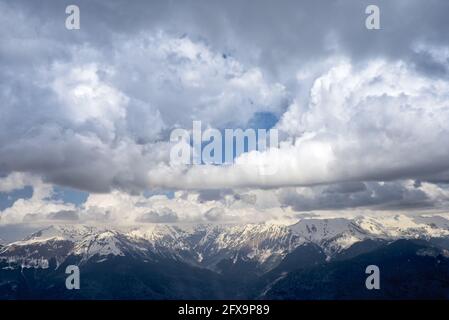 Mountain snow-capped peaks in the clouds. Tourist routes. Extreme tourism, extreme sports. Climbing the peaks. Stock Photo