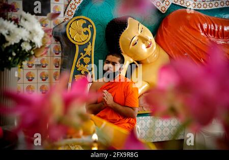 Kuala Lumpur, Malaysia. 26th May, 2021. A Buddhist monk wearing a face mask prays in an empty Buddhist temple during the Wesak Day celebration.The Wesak day, commemorates the birth, enlightenment and the passing away of Gautama Buddha, celebrated by Buddhists around the world. Malaysian has adopted a new way of celebrating Wesak Day with the Movement Control Order enforcement, all social and religious gathering are strictly prohibited. (Photo by Wong Fok Loy/SOPA Images/Sipa USA) Credit: Sipa USA/Alamy Live News Stock Photo