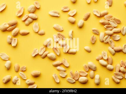 roasted salted peanuts on yellow background, top view Stock Photo