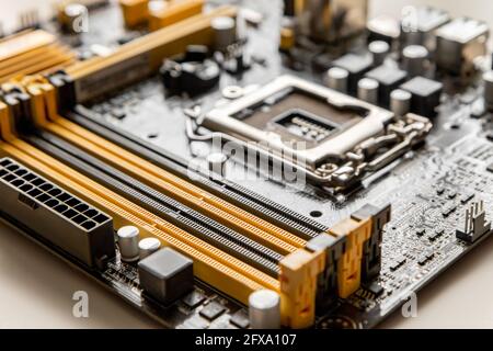 Part of the motherboard with a slot for placing RAM modules against the background of a blurred processor socket Stock Photo